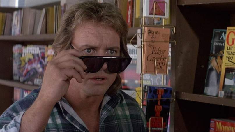 A meme of Rowdy Roddy Piper, removing his sunglasses to get a look at something, in the movie They Live.